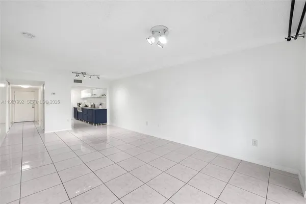 a view of empty room with kitchen