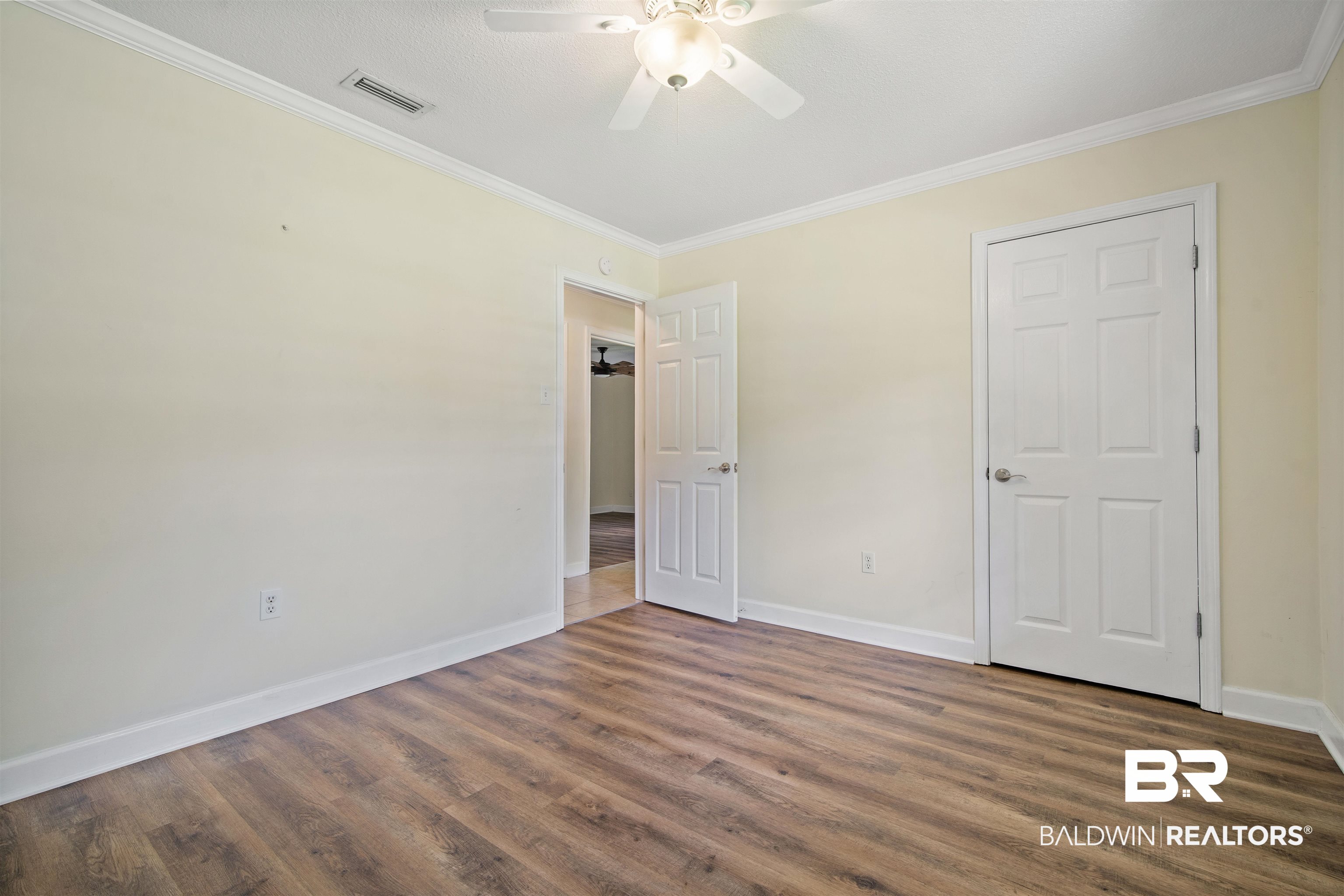 1325 Pawnee Circle Saraland, AL 36571 - Photo 19 of 26 Unfurnished bedroom with ornamental molding, wood finished floors, and ceiling fan