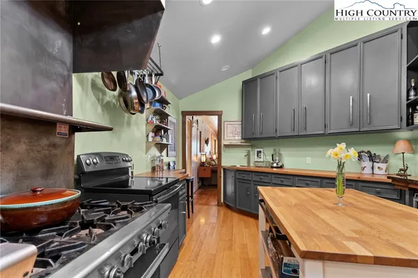 a kitchen with stainless steel appliances granite countertop a sink a stove and a wooden floors