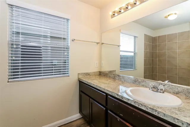 a bathroom with a granite countertop sink and a mirror