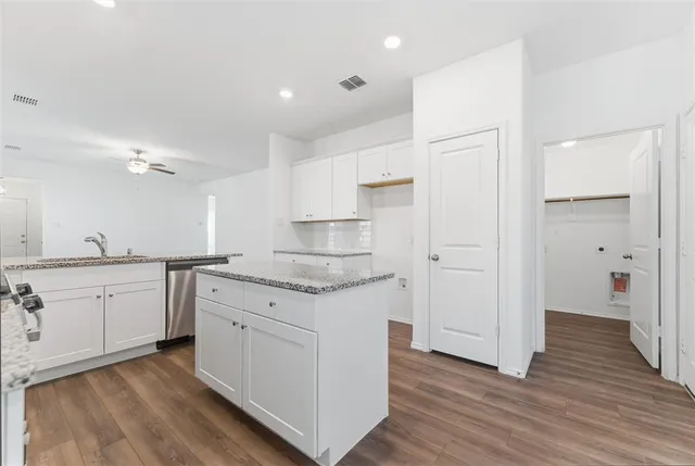 a kitchen with granite countertop white cabinets and white appliances
