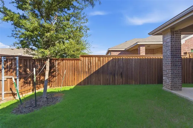 a view of backyard with wooden fence