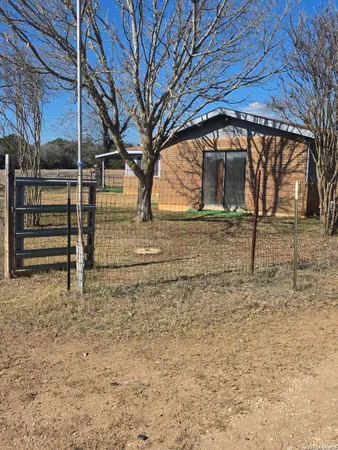 a view of a yard with wooden fence