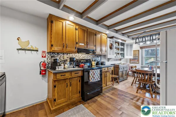 a kitchen with stainless steel appliances granite countertop a stove a sink dishwasher and cabinets with wooden floor
