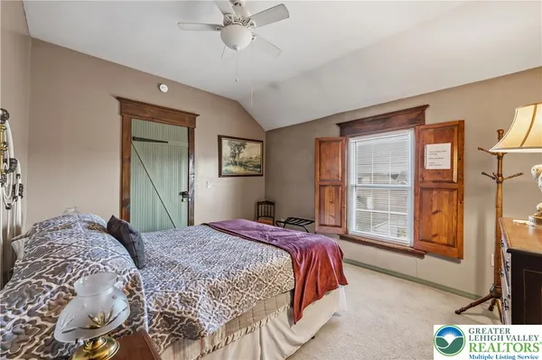 a bedroom with a large bed and a flat tv screen