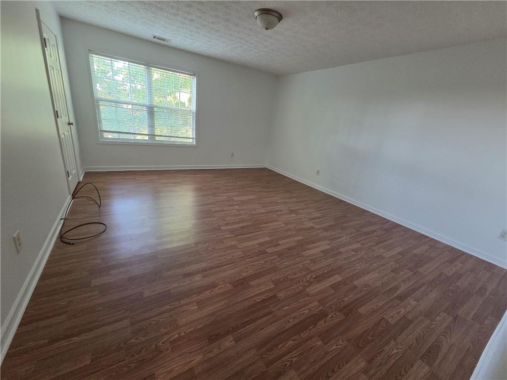 5834 Bridgeport Court Flowery Branch, GA 30542 - Photo 13 of 19 an empty room with wooden floor and windows
