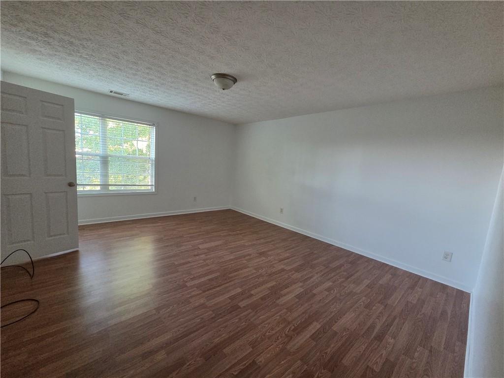 5834 Bridgeport Court Flowery Branch, GA 30542 - Photo 15 of 19 an empty room with wooden floor and windows