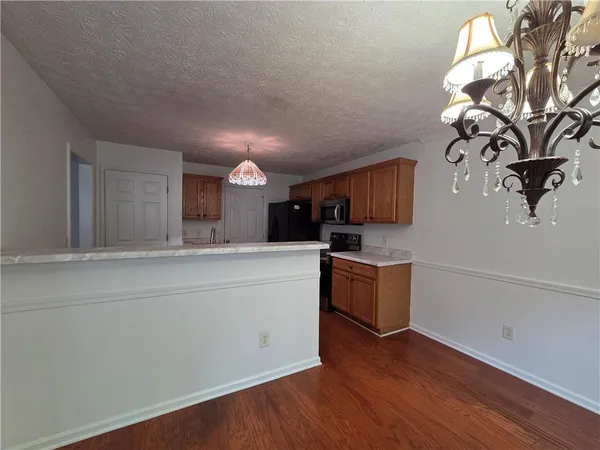 a kitchen with cabinets wooden floor and stainless steel appliances