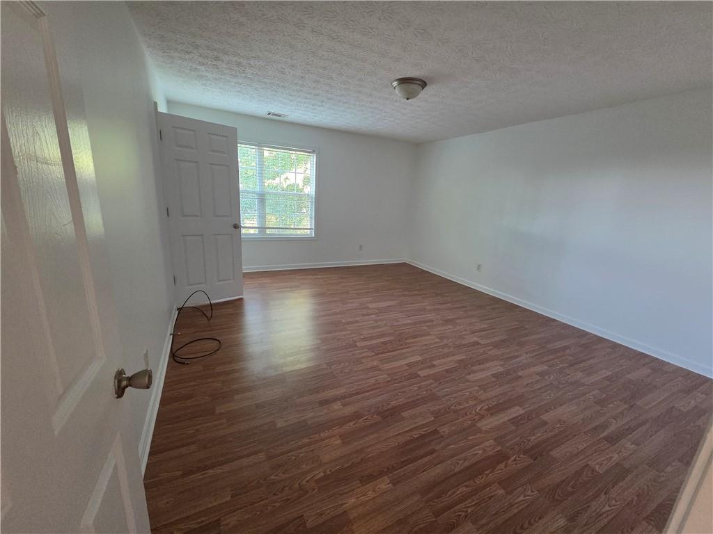 5834 Bridgeport Court Flowery Branch, GA 30542 - Photo 5 of 19 an empty room with wooden floor and windows