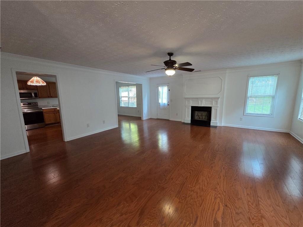 5834 Bridgeport Court Flowery Branch, GA 30542 - Photo 6 of 19 a view of an empty room with wooden floor and a window