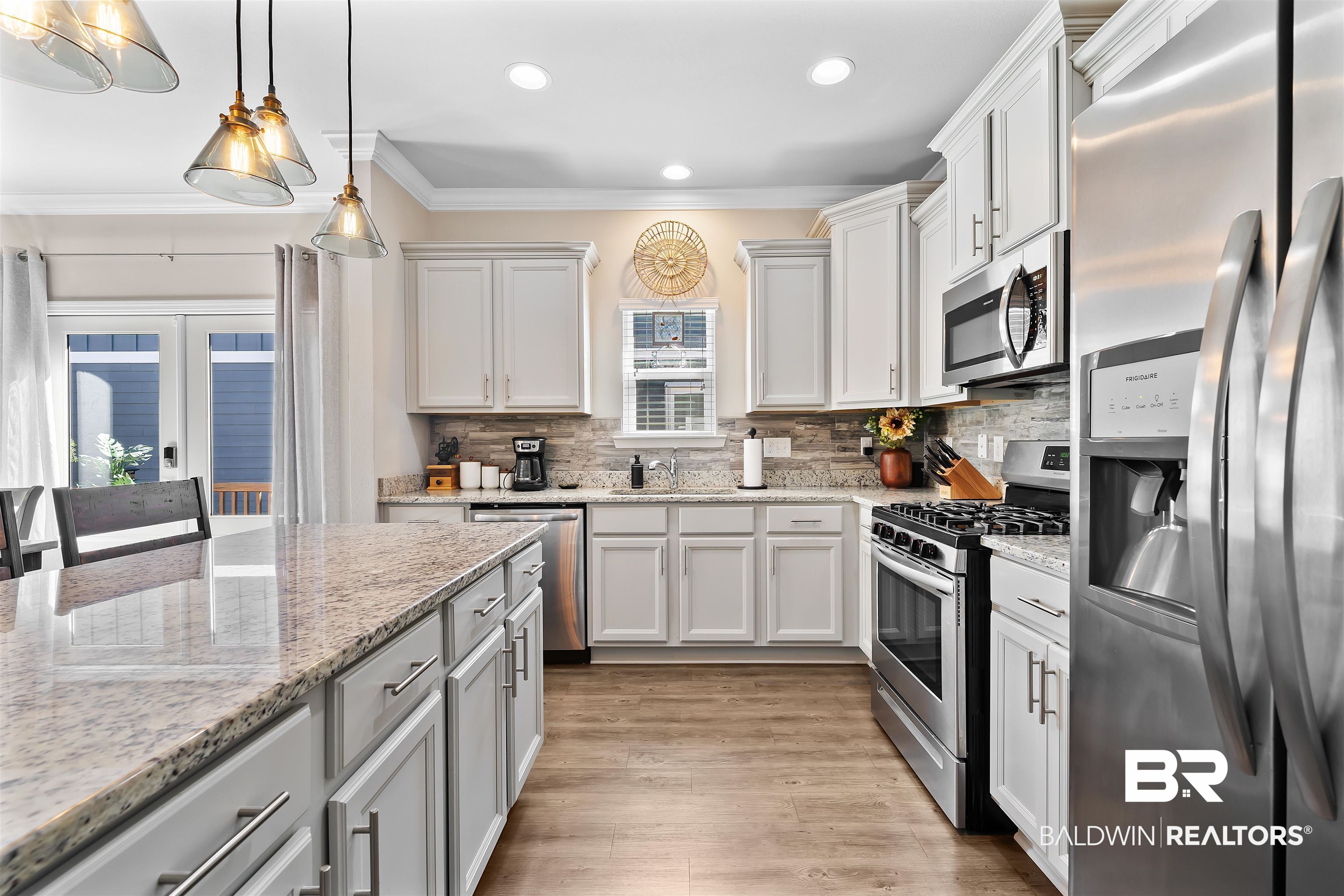 1221 Primrose Lane Foley, AL 36535 - Photo 24 of 29 Kitchen with light wood-style flooring, ornamental molding, decorative backsplash, appliances with stainless steel finishes, and pendant lighting
