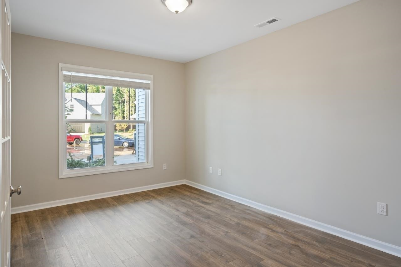 267 Madden Rose Loop Garner, NC 27529 - Photo 11 of 41 an empty room with wooden floor and windows