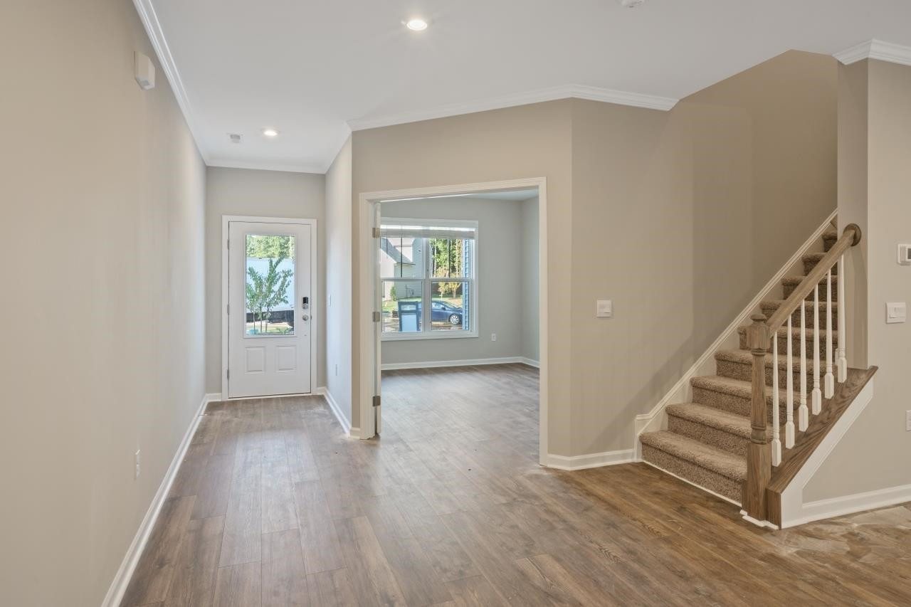 267 Madden Rose Loop Garner, NC 27529 - Photo 13 of 41 a view of a hallway with wooden floor and stairs