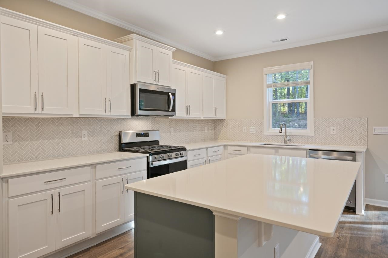 267 Madden Rose Loop Garner, NC 27529 - Photo 21 of 41 a kitchen with white cabinets and a stove top oven