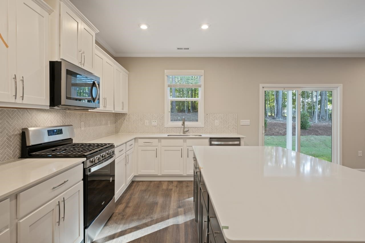 267 Madden Rose Loop Garner, NC 27529 - Photo 22 of 41 a kitchen with a stove a sink and a microwave