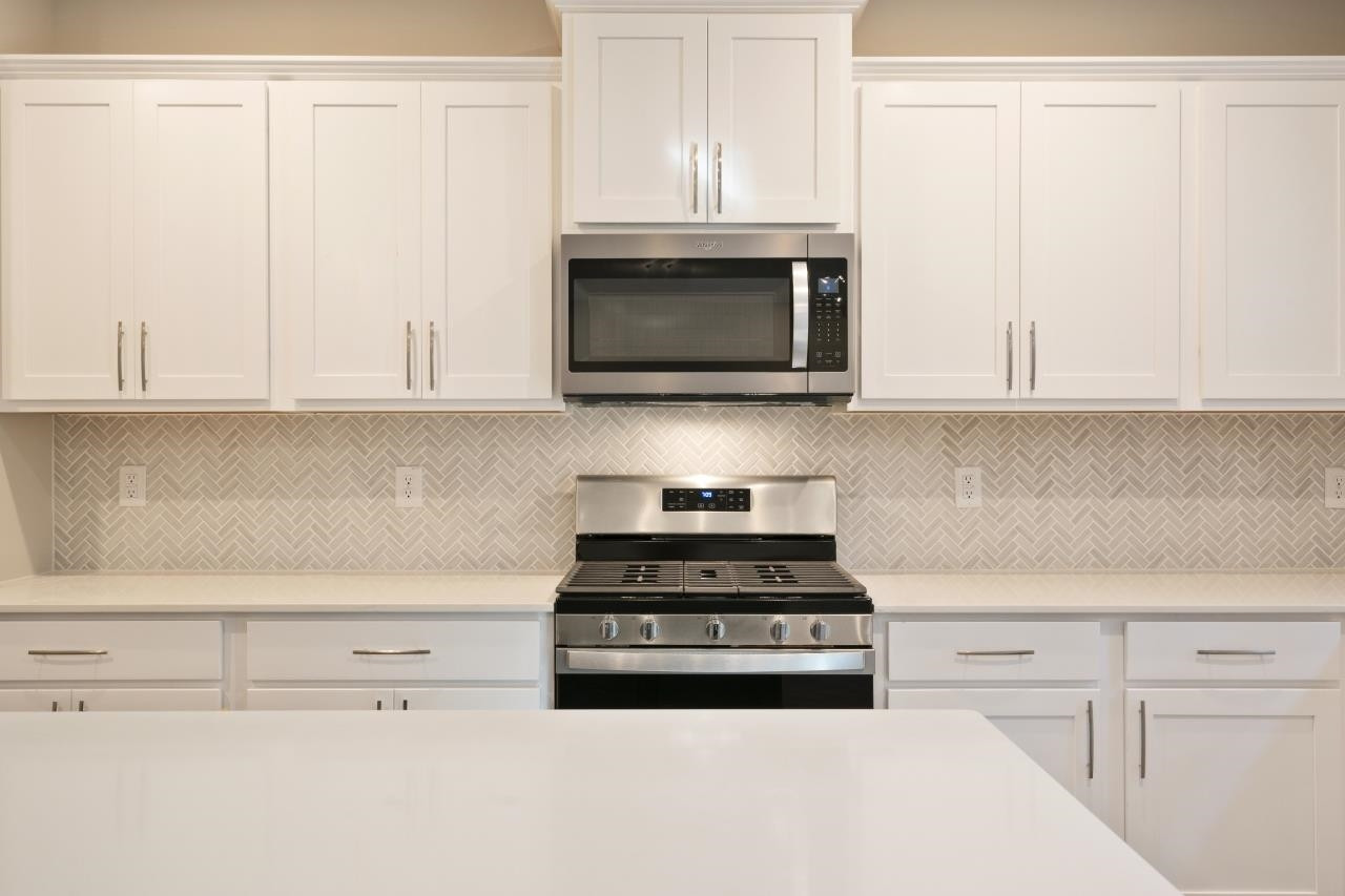 267 Madden Rose Loop Garner, NC 27529 - Photo 23 of 41 a kitchen with granite countertop white cabinets and stainless steel appliances