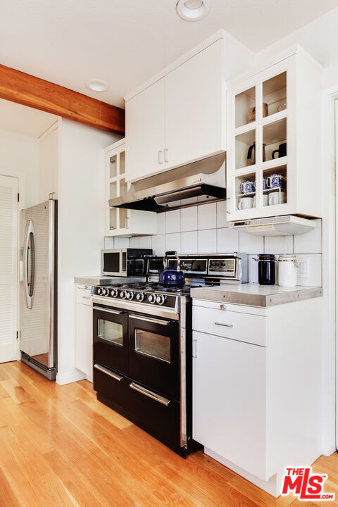 9018 Elevado Avenue West Hollywood, CA 90069 - Photo 15 of 32 a kitchen with stainless steel appliances granite countertop a stove and a refrigerator