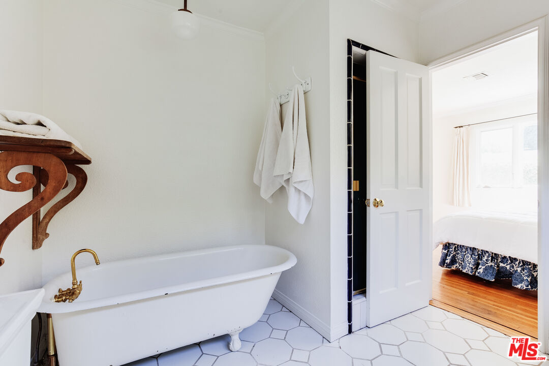 9018 Elevado Avenue West Hollywood, CA 90069 - Photo 19 of 32 a bathroom with a tub shower and window