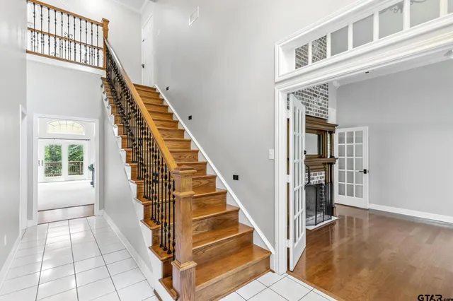 a view of a livingroom with a fireplace chandelier and windows