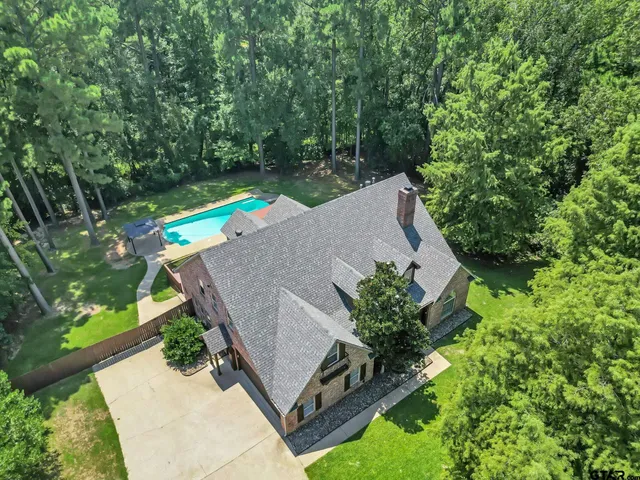 a spacious en suite bathroom with a large mirror a sink and a large window