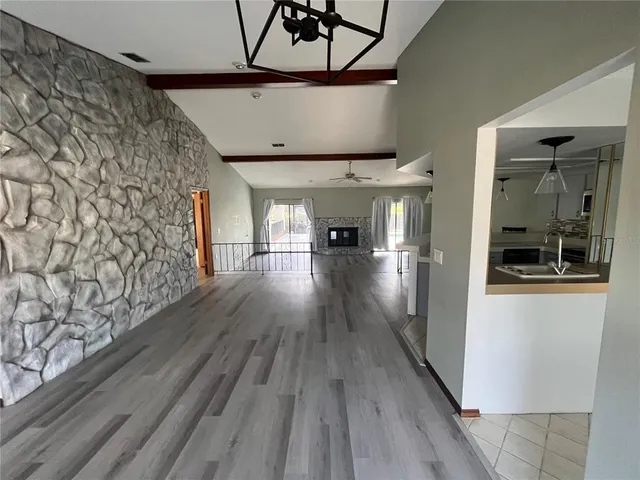 a kitchen with stainless steel appliances a sink a stove a microwave a refrigerator cabinets and a dining table