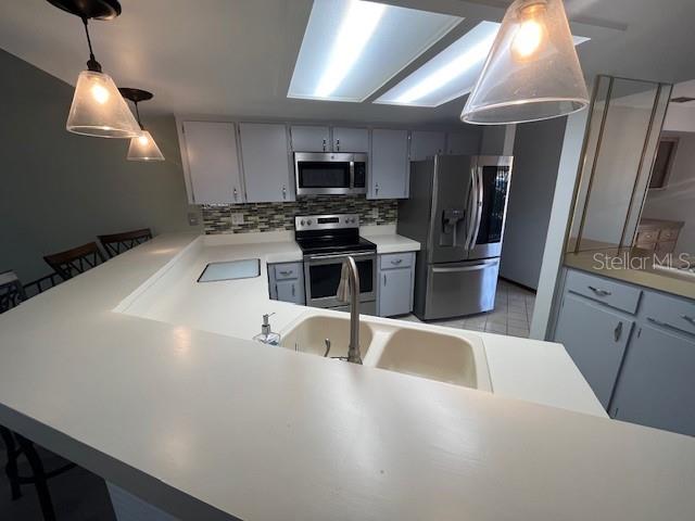 5375 Patricia Place Weeki Wachee, FL 34607 - Photo 23 of 61 a kitchen with stainless steel appliances a sink a stove a microwave a refrigerator cabinets and a dining table