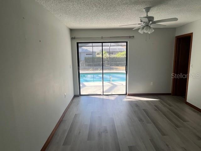 5375 Patricia Place Weeki Wachee, FL 34607 - Photo 47 of 61 an empty room with wooden floor and windows with curtains