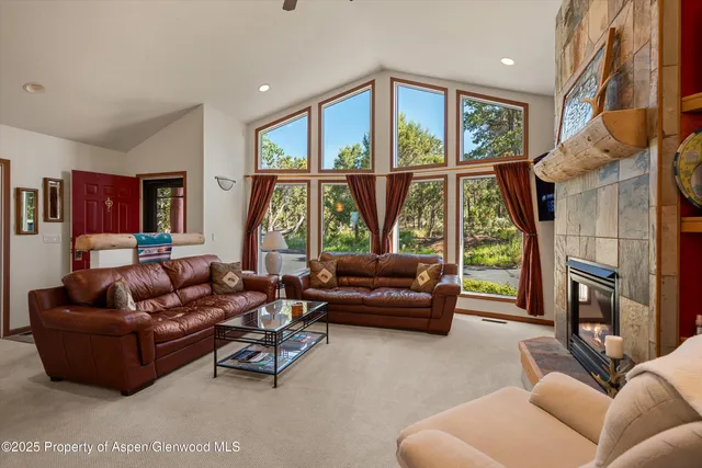 a living room with furniture a large window and a fireplace