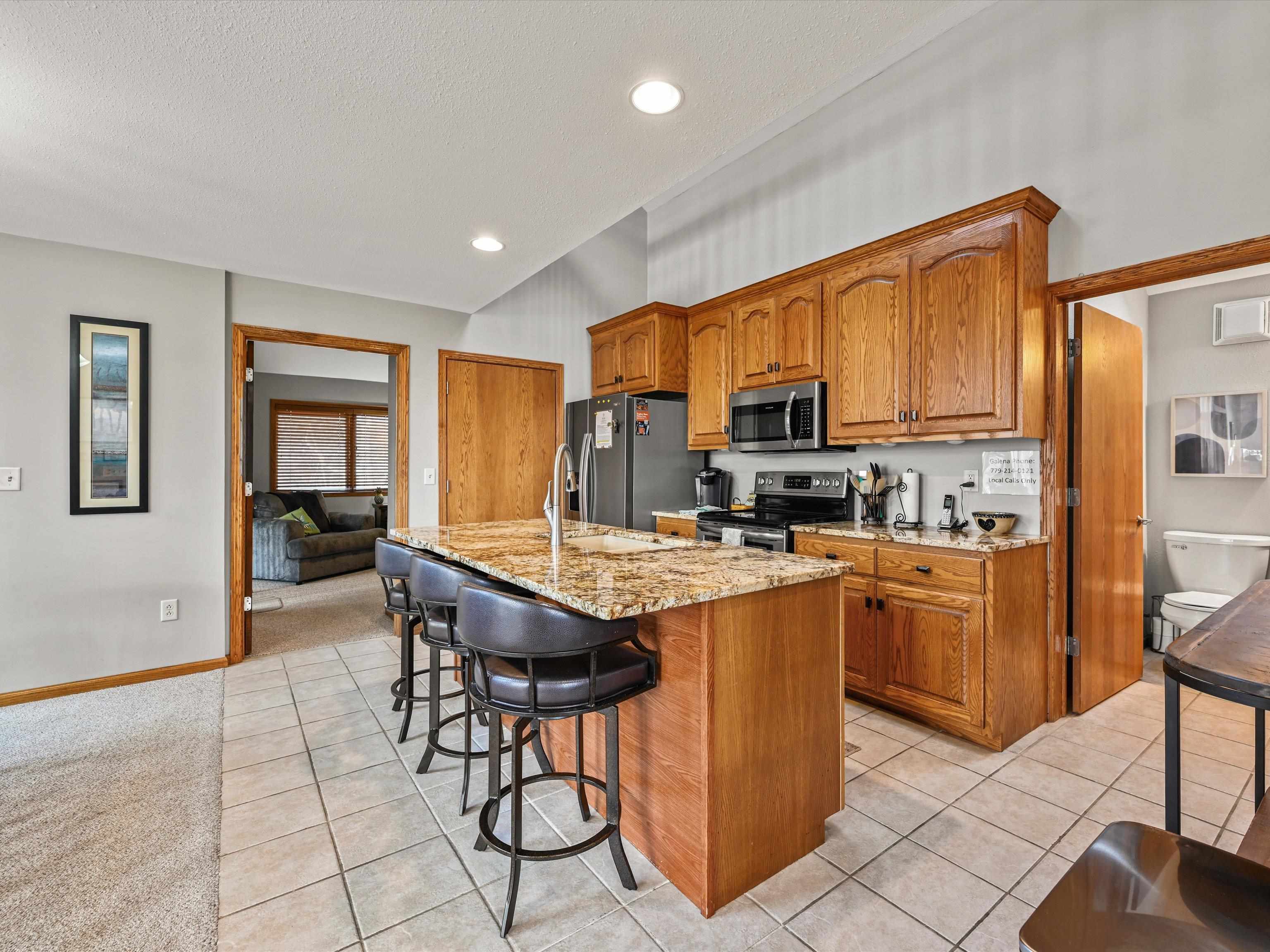 1 High Ridge Run Galena, IL 61036 - Photo 32 of 40 a kitchen with stainless steel appliances granite countertop a stove a sink dishwasher a dining table and chairs with wooden floor