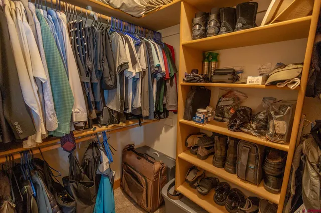 a view of walk in closet with clothes and shoes