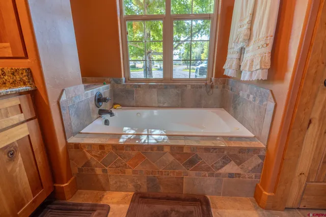 a bath tub sitting in a bathroom next to a window