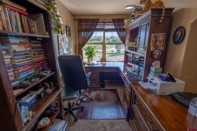 a view of a workspace with furniture and a window