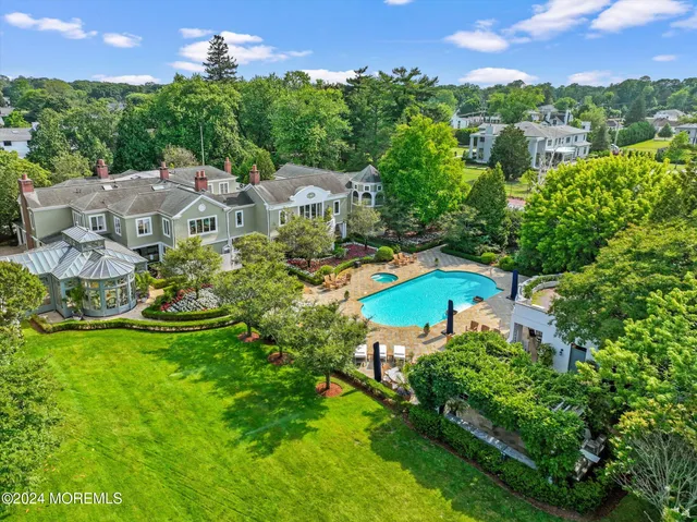 an aerial view of residential houses with outdoor space and trees
