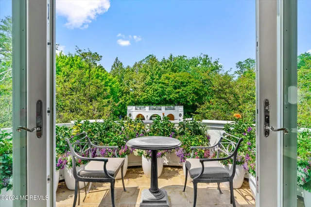 a backyard with table and chairs with plants