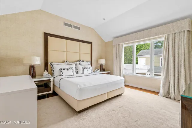 a spacious bedroom with a bed and a large window