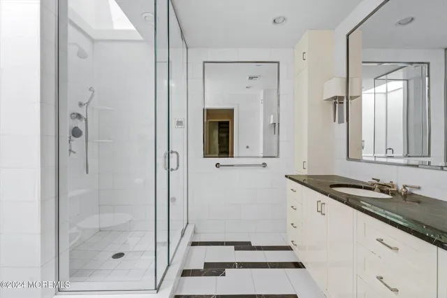 a bathroom with a granite countertop sink mirror and shower