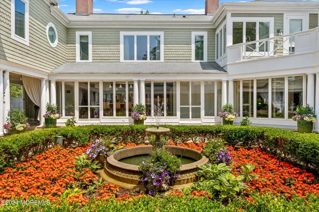 front view of a house with a large window and flower plants