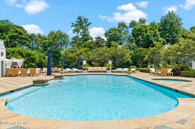 a view of swimming pool with lawn chairs and plants