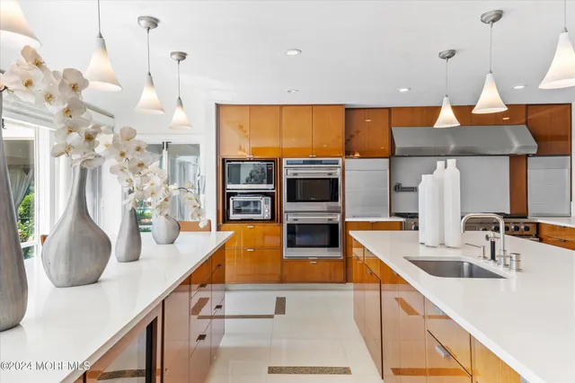 a kitchen with stainless steel appliances kitchen island granite countertop a sink and a living room view