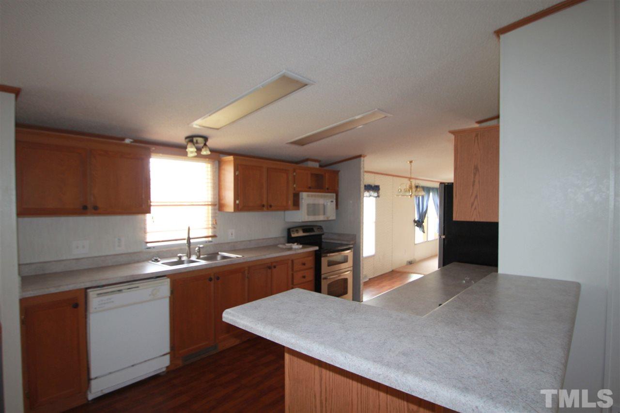 545 Duke Drive Rougemont, NC 27572 - Photo 4 of 14 a kitchen with stainless steel appliances granite countertop a sink stove and refrigerator
