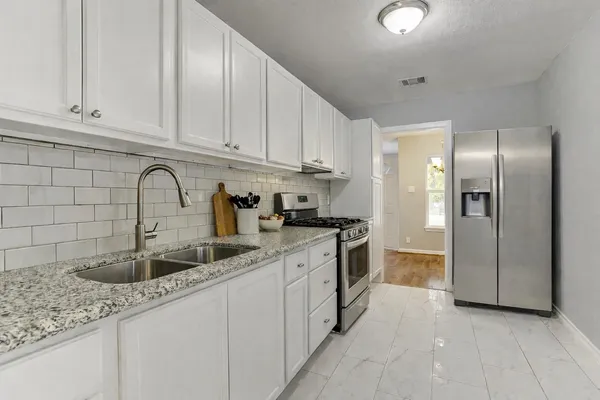 a kitchen with stainless steel appliances granite countertop a sink and cabinets