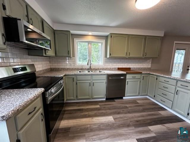 4207 Trinity Road Duluth, MN 55811 - Photo 12 of 40 Kitchen with stainless steel appliances, dark wood-type flooring, sink, and backsplash
