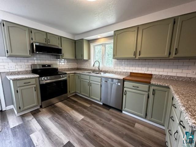 4207 Trinity Road Duluth, MN 55811 - Photo 13 of 40 Kitchen with appliances with stainless steel finishes, exhaust hood, sink, and dark wood-type flooring