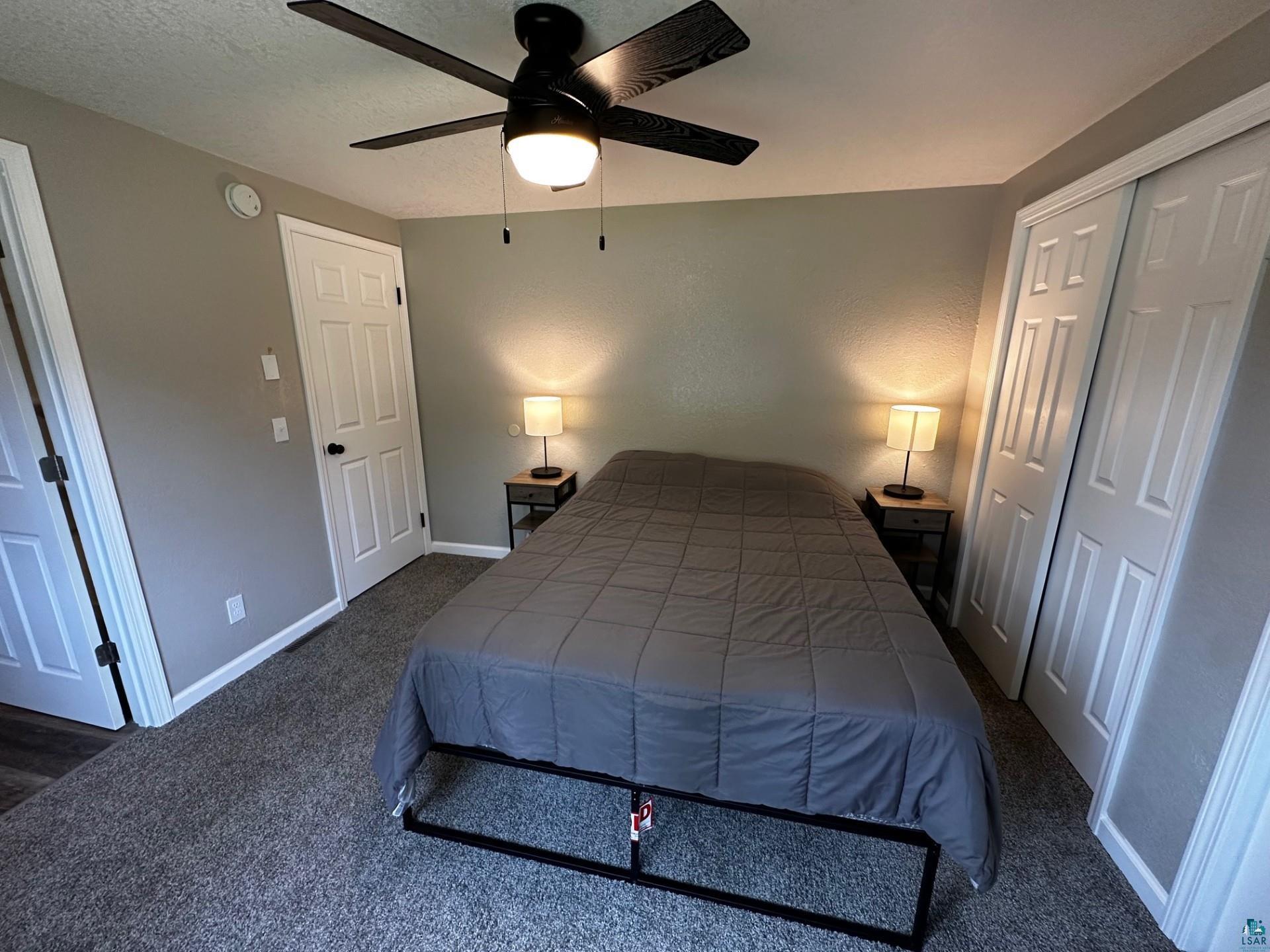 4207 Trinity Road Duluth, MN 55811 - Photo 21 of 40 Bedroom featuring a closet, dark colored carpet, and ceiling fan