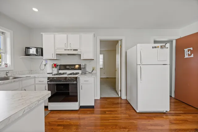 a kitchen with stainless steel appliances granite countertop a refrigerator stove and sink