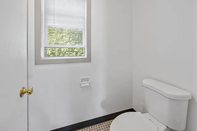 a white toilet sitting next to a window