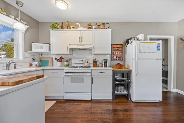 a kitchen with refrigerator cabinets and wooden floor