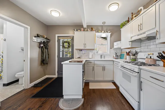 a kitchen with a refrigerator and white cabinets