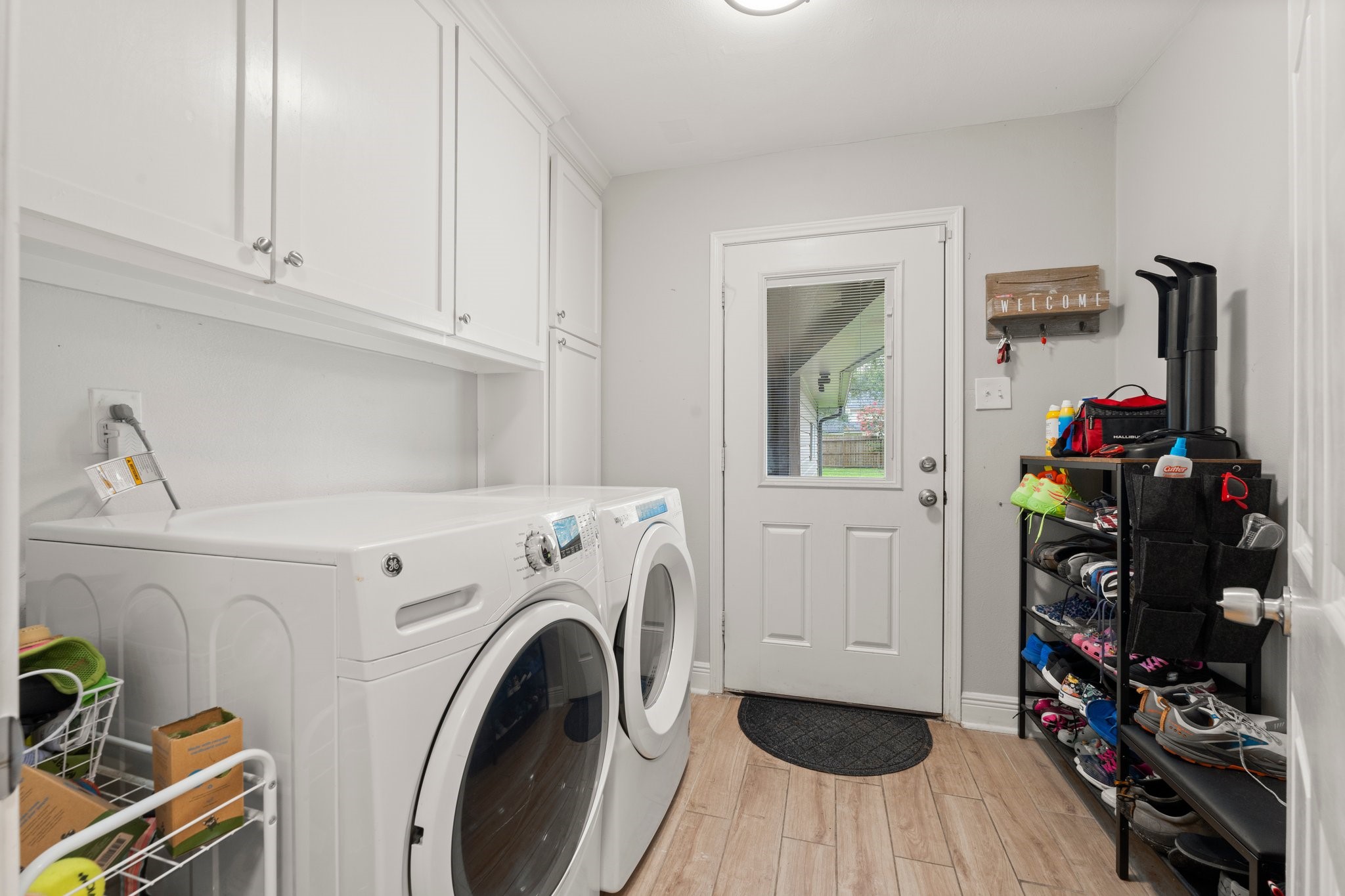 6030 Craigway Road Spring, TX 77389 - Photo 19 of 45 Laundry room with ample cabinet storage, organized shelving for shoes and essentials and access to the backyard.
