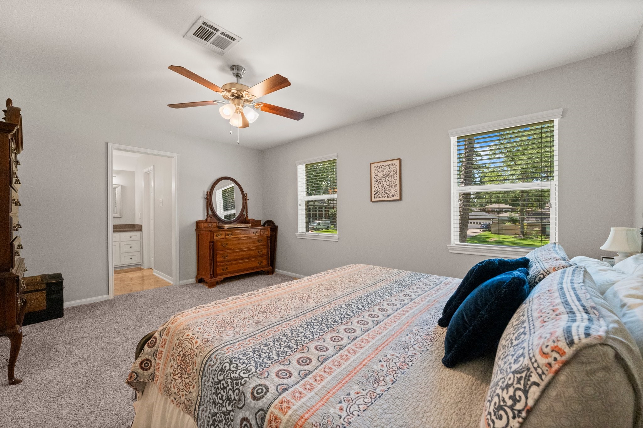 6030 Craigway Road Spring, TX 77389 - Photo 27 of 45 Spacious bedroom features plush carpeting, and large windows offering plenty of natural light. It includes an ensuite bathroom, creating a cozy and functional space.